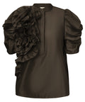 GOSSIA AnnsofiGO Blouse&nbsp;er en elegant og moderne bluse, der forener tidløs femininitet med et nutidigt twist. De korte, voluminøse ærmer tilføjer dramatik og raffinement til silhuetten, mens den høje hals med frontlukning og en smuk, dekorativ blomst på siden giver et særligt og iøjnefaldende udtryk.