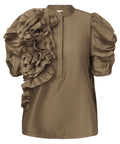 GOSSIA AnnsofiGO Blouse&nbsp;er en elegant og moderne bluse, der forener tidløs femininitet med et nutidigt twist. De korte, voluminøse ærmer tilføjer dramatik og raffinement til silhuetten, mens den høje hals med frontlukning og en smuk, dekorativ blomst på siden giver et særligt og iøjnefaldende udtryk.