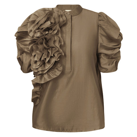 GOSSIA AnnsofiGO Blouse&nbsp;er en elegant og moderne bluse, der forener tidløs femininitet med et nutidigt twist. De korte, voluminøse ærmer tilføjer dramatik og raffinement til silhuetten, mens den høje hals med frontlukning og en smuk, dekorativ blomst på siden giver et særligt og iøjnefaldende udtryk.