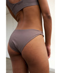 Rethinkit Studios Bikini Bottom Brief BAY i farven Walnut er et stilfuldt og komfortabelt valg til strandgarderoben.