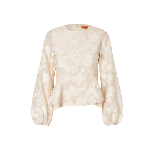 Den taljerede pasform med peplum-snit fremhæver silhuetten, mens puffede ærmer med elastiske manchetter og en rund halsudskæring tilføjer feminine detaljer. Den skjulte lynlås i ryggen sørger for et elegant finish, og hele blusen emmer af STINE GOYA’s kunstneriske DNA.